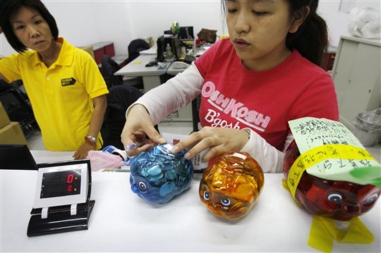 In this photo taken on Nov. 11, 2011, a campaign volunteer seals a \"Piggy Bank\" containing donations at the opposition Democratic Progressive Party's 2012 presidential candidate Tsai Ing-wen's campaign headquarters in Banciao, northern Taiwan. Inspired by the popular fairy tale \"The Three Little Pigs,\" the party has won over tens of thousands of supporters with the campaign, which encourages people to make donations to the party in colorful, plastic piggy banks. (AP Photo/Wally Santana)